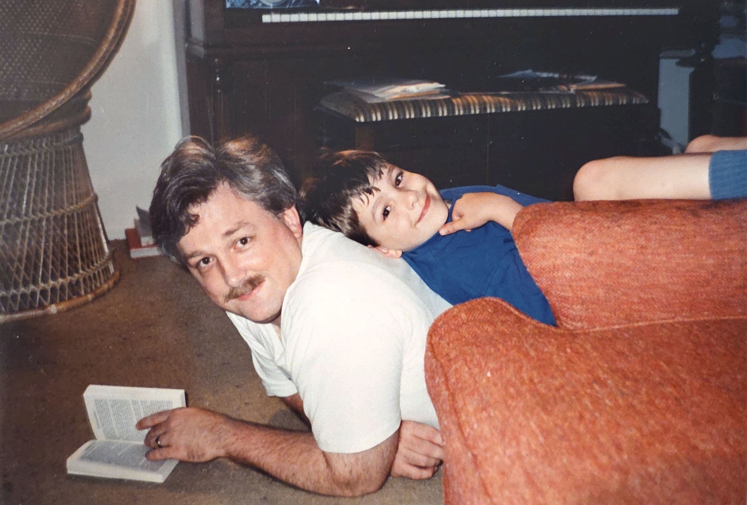 Doug reading on the floor with his son Josh